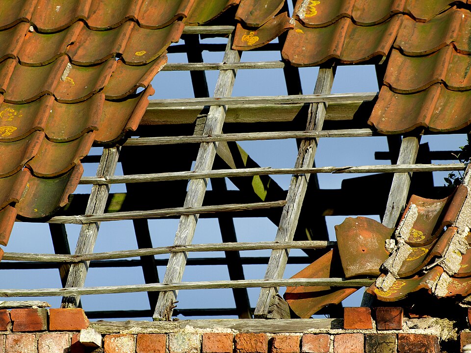 Slipped and missing tiles leave the battens and underlayment exposed to sun and rain.