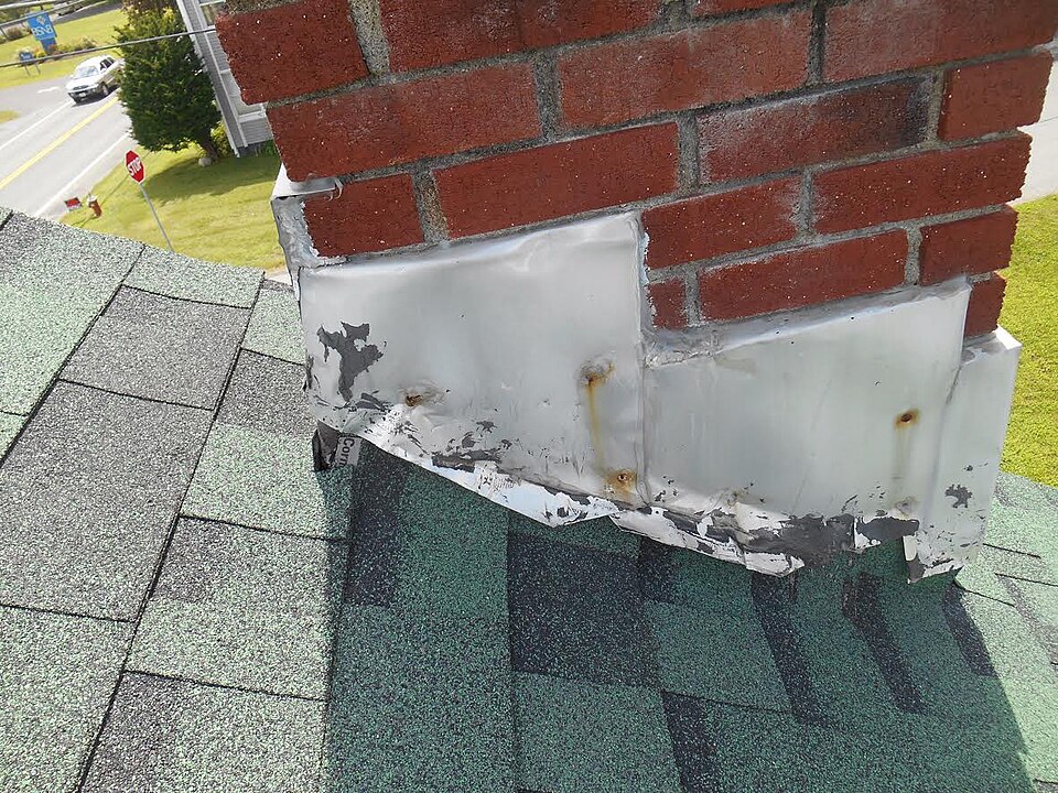 Failed chimney flashing pulling away from the brick — the #1 place leaks start.