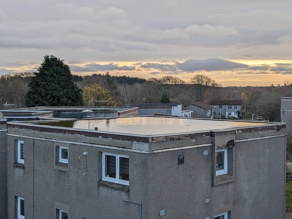 Water still standing on a flat roof long after rain is an early membrane failure sign.