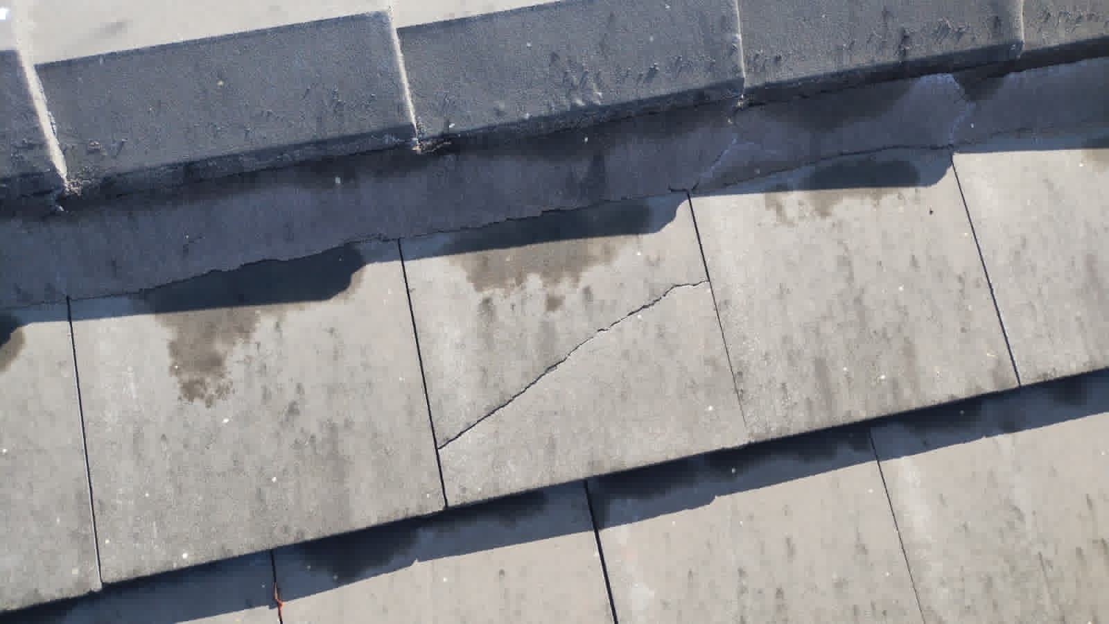 Cracked concrete roof tile with water staining on a Miami home — an early roof leak sign visible from the ground