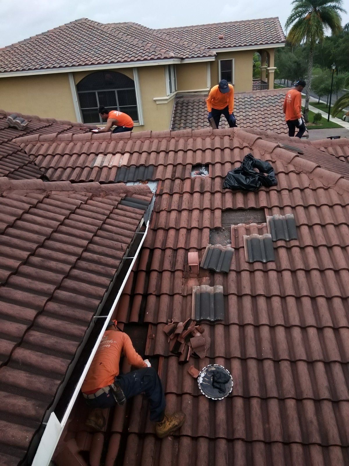Canopy Roofing crew replacing broken tiles on a South Florida tile roof